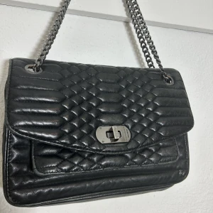 Zadig Voltaire väska svart - Snygg väska från Zadig som är använd mycket, vilket går att se på bilderna. Säljes i befintligt skick. Väskan är cirka 26 x 18 cm