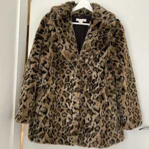 Fuskpäls strl S - Cool jacka, leopardmönstrad fuskpäls. Sparsamt använd och i nyskick. Stängs med tre tryckknappar och har två fickor. Storlek S