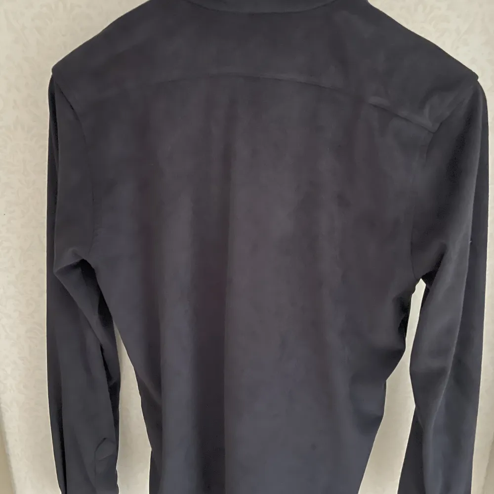 En tidlös marinblå overshirt som är tillverkad av ett mjukt och flexibelt tyg. Jackan har sin plats vid alla tillfällen och är perfekt att använda över en t-shirt eller under ytterjackan en kall vinterdag . Jackor.