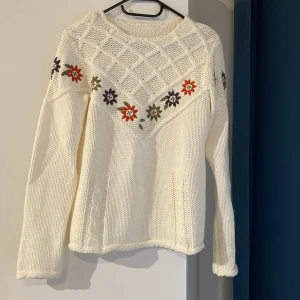 Stickad tröja med blommor  - Stickad tröja med blommotiv.  Varan säljs i befintligt skick.  Frakt tillkommer <3