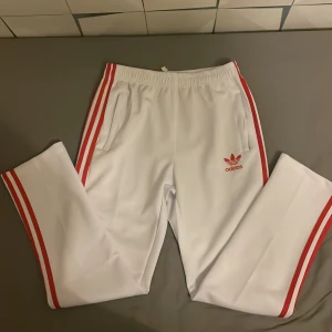 Vit/Röda Adidas byxor  - En par gammla adidas byxor som inte används. Är size Xl men passar även L. Nyskick
