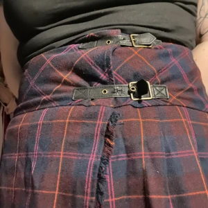 Längre kjol - Kilt liknande kjol med spännen. Fint använt skick. En knapp på insidan saknas men det går att sätta dit en ny. 