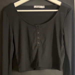 Ribbad topp  - Använd ett få tal gånger,har fyra knappar fram som detalj(går att knäppa upp) och en urringning 