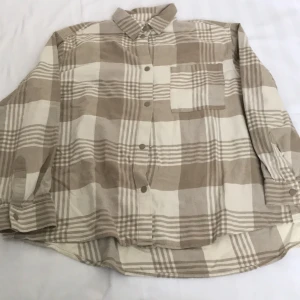 Pläd oversized skjorta  - - Plagg: Skjorta - Mönster: Pläd - Färg: Creme/benvit, ljusbrun - Storlek: M - Märke: Weekday - Skick: Mycket bra - Egenskaper: Uppknappbar, snäpplås, mjuk, varm, oversized, krage, ficka till höger  Kontakta mig gärna vid frågor 💕 