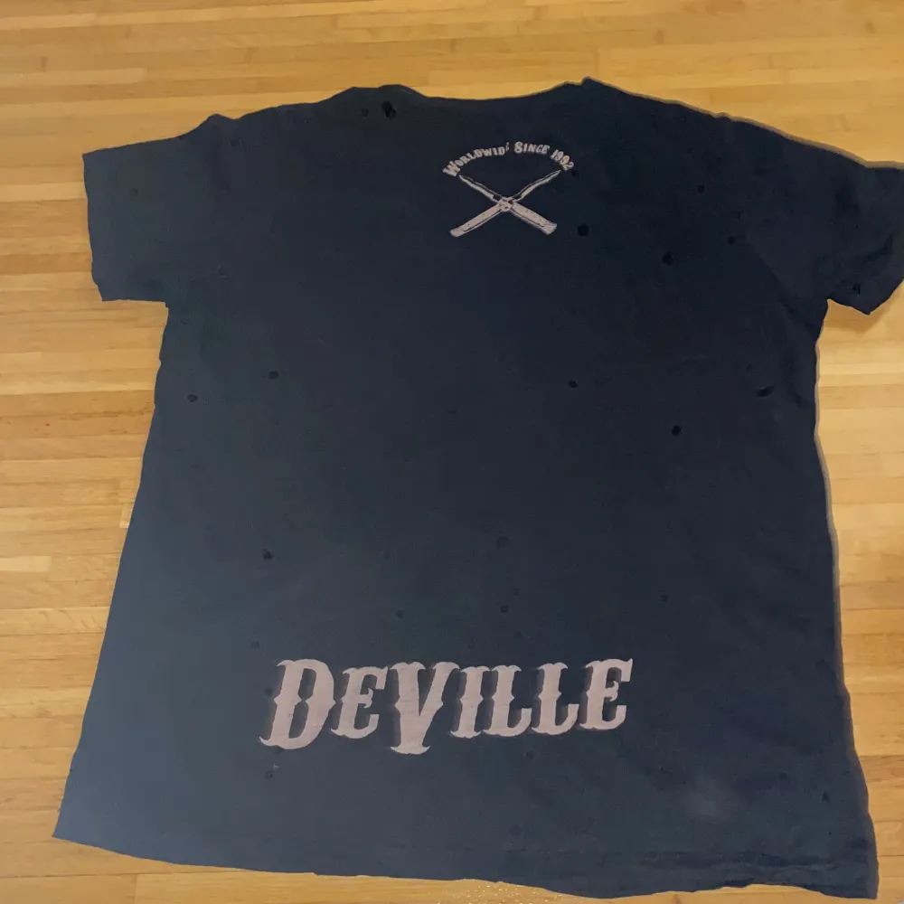 Deville t-shirt ”sharp knives & loud guns”. Vet inte vart ifrån den är, finns ingen lapp. Cool skalle och pistoler tryck.  Använd köp nu!. T-shirts.