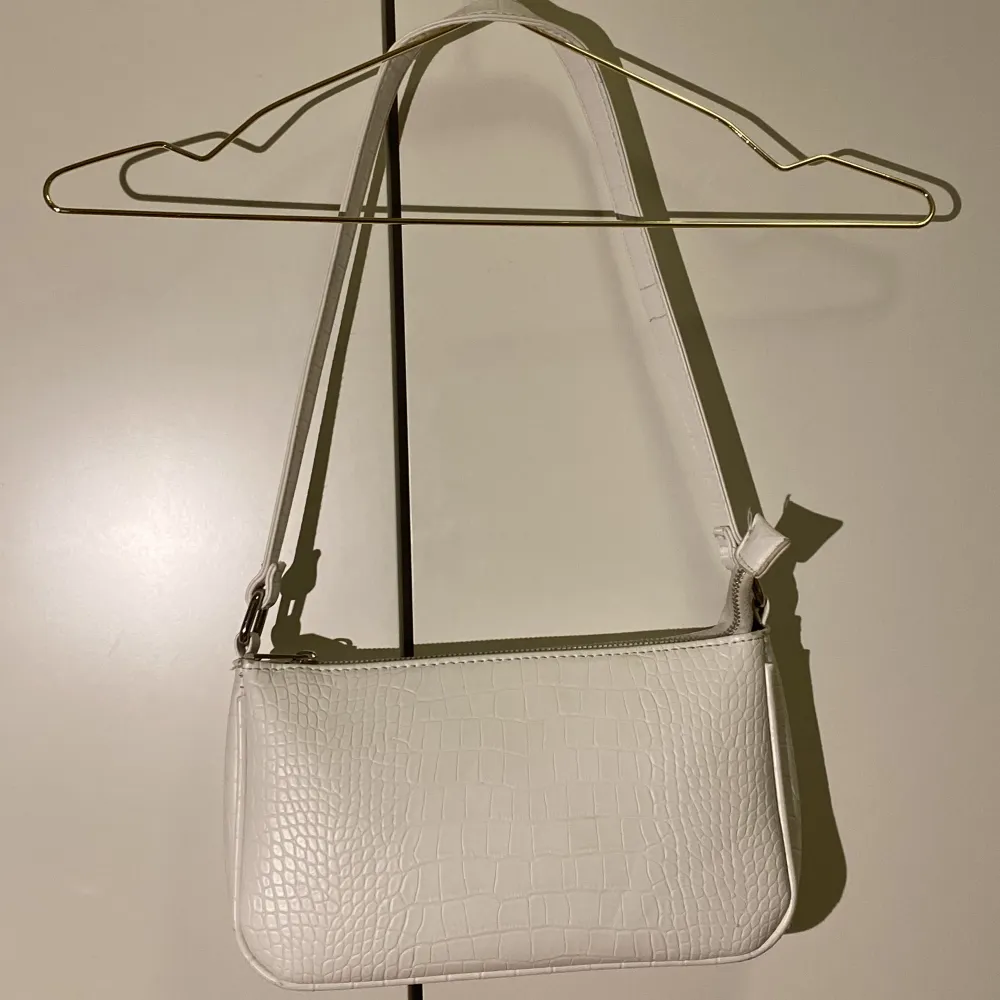 Jätte söt vit väska i ”krokodil mönster”. Materialet är fale läder! Köpt på H&M🫶🏼. Väskor.
