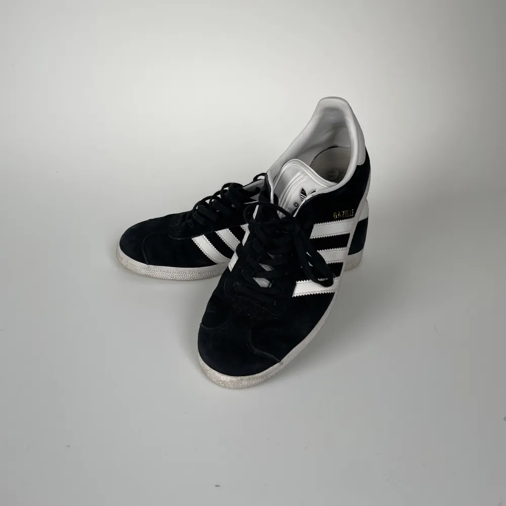 Oavsett om du är en sneaker-entusiast eller bara letar efter klassiska och bekväma skor, är Adidas Original Gazelle det perfekta valet. Dock ett litet slitage på den vänstra skons häl.. Skor.