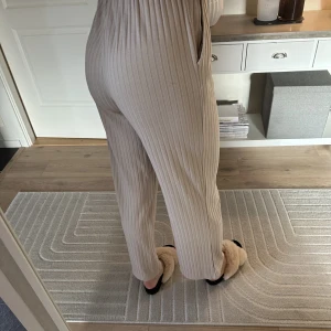 Beige ribbade byxor - Från jacqueline de yong, inköpta på Nelly. Hög midja med resår och utsvängda ben. I använt men fint skick! Stl S men passar snarare XS då resåren i midjan är rätt tight.