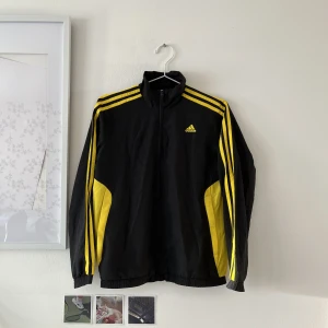 Svart/gul adidasjacka - Säljer denna adidasjacka i fint skick 💛🖤Stl. 11-12 Y, men passar även som XS.    Köpt second hand, säljer då den aldrig kommer till användning.