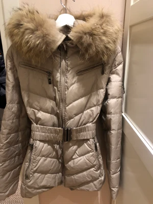 Hollies dunjacka - Med fin avtagbar päls.  Storlek 44, men liten i storlek passar 40/42.  Går över rumpa. 