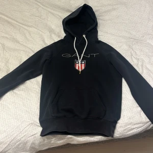 Gant Hoodie - Mörkblå Gant Hoodie, väl använd men i bra skick. Barnmodell.   Säljer billigt pga. använder aldrig längre (: 