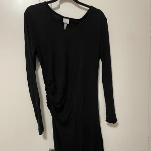Klänning - Svart klänning med resår på sidan, går till mitten av vaderna(jag är 170)