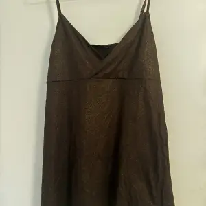 Ett brunt glittrigt linne från Lindex i storlek M.