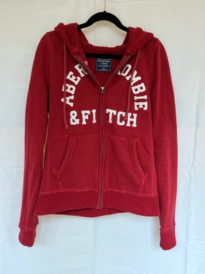 ziphoodie från abercrombie&fitch - svinsnygg, röd ziphoodie i xs som passar perfekt nu på hösten💃köpt för 600kr och knappt använd!
