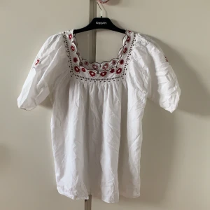 Sommarblus - Supergullig sommarblus med blomdetaljer. Väldigt skönt material och använd fåtal gånger. Inga defekter 