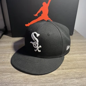 New era keps  - Säljer en äkta svart New Era keps i storlek 7 1/8 (56.8cm) Den är andvänd men i 10/10 skick. Den har inga skador eller defekter och är köpt från hatstore. Har man några frågor eller vill ha mer bilder är det bara att höra av sig 😁