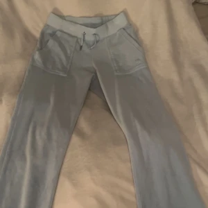 Ljusblåa juicybyxor  - Jag säljer nu mina ljusblåa juicybyxor pågrund av att jag inte använt dom mycket utan att dom bara legat i garderoben. En metall bit från snöret har gått av, den åkte av i tvätten. Byxorna är i storlek Xs och är köpta för 1200kr. 