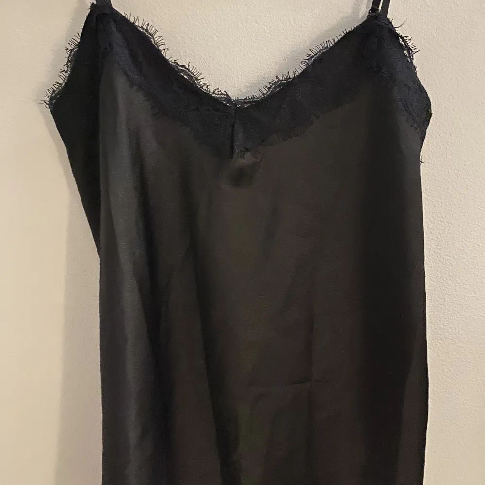 Det är ett svart spets linne som kan användas både som pyjamaslinne men även ett vanligt plagg. Materialet är silkes tror jag då det känns som det. Skriv vid fler frågor 💕. Toppar.