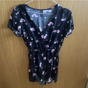 Blommig byxdress - Supergullig svart blommig byxdress från hm i Stl 36! Superfint skick då den endast är använd 2 gånger!
