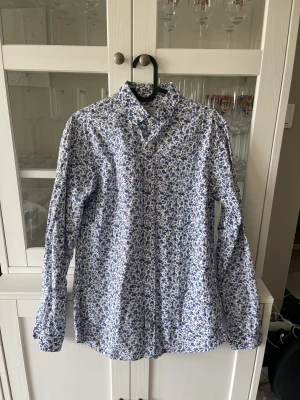 Blommig skjorta - Vit skjorta med blått blommigt mönster. Slimfit