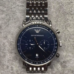 Emporio Armani Klocka - Tja! Säljer nu min fina Armani klocka då jag inte har någon användning av den längre. Det finns små små ”hairlines” på baksidan av armbandet. Klockan är kortad men alla länkar finns kvar, så kan lägga tillbaka alla vid önskemål. Finns i Växjö. Bvsa! 