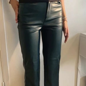 Mörkgröna skinnbyxor  - Säljer dessa jättefina mörkgröna skinnbyxorna i storlek 34! Modellen är 172 och byxorna passar perfekt i längden. Superbra skick ändast använda 2 gånger. Dessutom är de små i storleken🥰