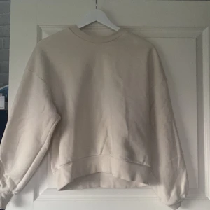krämvit sweatshirt - Skulle klassa den som krämvit men vissa hade nog sagt att den är ljusbeige. Passar bra till hösten och vintern då den är varm. Ganska kort enligt mig men de kan vara för att jag är 178cm lång. Kan vara lite tajt och kort i ärmarna enligt mig.