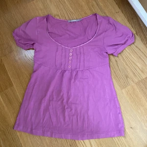 Lila topp - Lila lite ”utsvängd” topp med några knappar