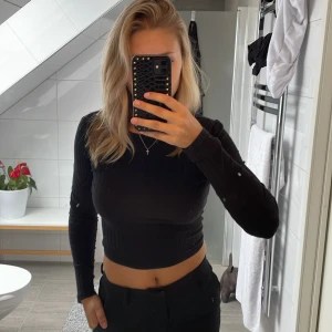 ribbad croppad tröja - En ribbad & croppad tröja från Na-kd med öppen rygg och en liten knytning. Säljer då den ej kommer till användning.