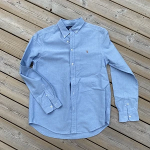 Ralph Lauren skjorta - Supersnygg klassisk button-down skjorta från Ralph Lauren, strl Xl (18-20 år). Ljusblå med vita knappar och RL-logga broderad på bröstet. Knappt använd, nyskick! 