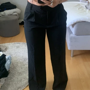 Svarta kostymbyxor  - Fina svarta kostymbyxor från BERSHKA, har en vit kant på innersidan så man kan ha både upp vikt eller som vanligt, knappt använda 