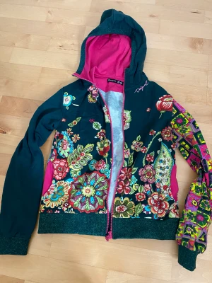 Huvtröja med mönster - Mycket mönster med dragkedja. Oanvänd men har inte prislappar kvar.