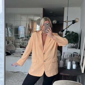 Kavaj från h&m - Kavaj från h&m i en underbar korallfärg. Använd en gång så i väldigt bra skick. Färgen är mer som på bild två i verkligheten! 