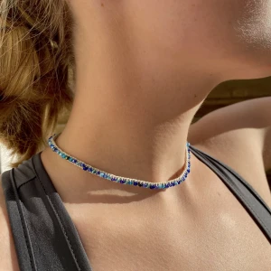 Halsband - Handgjort halsband med mackrame  runt ett mocka imitation band tillsammans med varierade blåa glaspärlor!💙 halsbandet knyts till backsidan och har långa hängande band bak, som kan knytas till önskad stil! Totala längden på halsbandet är 130 cm! 