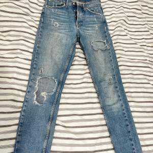 Jeans från Gina tricot med slitningar och många knappar