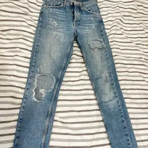 Jeans från Gina tricot med slitningar och många knappar