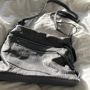 Säljer min gråa väska pga att den inte kommer till användning, fint skick använd ett fåtal gånger men sparsamt. Det är inte äkta skinn, den har många användbara fack och alla dragkedjor fungerar 👌. Köpt utomlands för ca. 200kr
