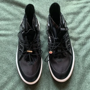 Skor 37 svart-vit - Så snygga svart-vita skor. Storlek 37. Gott skick, nyskick. Skorna är för små för mig. Tjock, mjuk, comfy sula. Vit sula, svart sko. Cool tryckknapp på elastiska skosnören. Coola sommarskor. Cityskor. Swisha - Mötas upp på Gröna linjen.