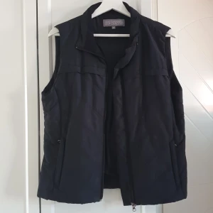 Väst  - Väst. Svart. Inte så tjock. Köpt på stadium. 