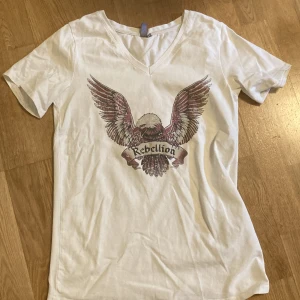 T-shirt - Vit t-shirt med coolt tryck. Aldrig använd :) står storlek s i tröjan men den är ganska stor. Tyget är jättestretchigt