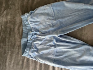 Juicy Couture byxor - Juicy byxor köpta på Kidsbrandstore i färgen ljusblå💓 Storlek 14/15 men är ca xs/s🫶🏼 Nypris är 850kr! Byxorna är i bra skick men lite slitna längst ner på baksidan då de va lite långa på mig och blev tyvärr slitna, inget stort man märker när man bär de💕