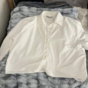 En kort/croppad långärmad skjorta som är vit. Den kommer ifrån Zara och köptes för ca 1,5 år sedan. Använts ett fåtal gånger och är i bra skick! Hör av er om ni är intresserade😊