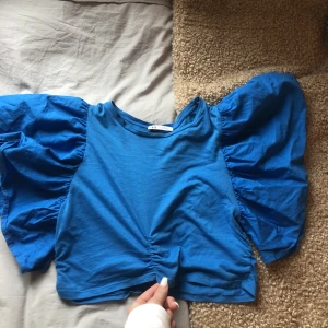 Blå topp - Säljer min superfina och eleganta klar blåa topp! Såå härlig färg! Toppen har puffärmar och är en kortare modell! Säljs då den inte används 💕