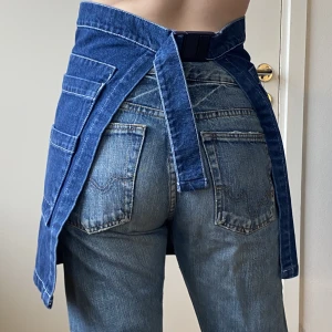 Jeanskjol/accessoar - Serviskjol i jeans med pripps blå logga!! Snygg över jeans! 
