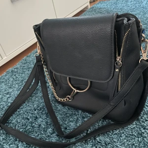 Väska - Flera band medföljer - kan användas som handväska, axelremsväska och ryggsäck 