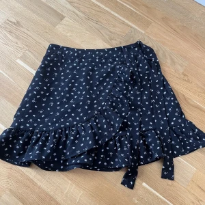Voljangkjol - Svart-blommig volang kjol i storlek M. I toppskick, Ingenting att anmärka på. 97% polyester/3% elastistan. Säljes för 150kr + frakt. Tryck på ”köp nu” för att köpa 