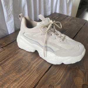 Sneakers köpta från NA-KD. Beige/gråa skor med litet reflexband på sidan. Använda fåtal gånger men ser helt nya ut, finns inga fläckar eller smuts på skorna. Storlek 37 🤎🤍🤎