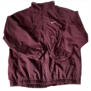 Nike vindjacka - Oanvänd Nike vindjacka, tunn och skön nu till våren, jättefin vinröd färg som inte riktigt kommer fram på bilderna, säljer den då jag tycker den sitter lite för stort på mig😭💗