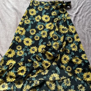 Kjol - Kjol med solrosmönster och en slit med volang