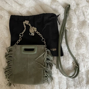 Mini Maje väska - Intressekoll på min superfina gröna mocka maje väska! Köpt för 2600kr på maje butiken i Paris. Färgen säljs ej längre på hemsidan💕Väskan är använd väldigt få gånger och har nästan inga synliga slitningar! Ett guldigt kedjeband+skjusterbart läderband med!